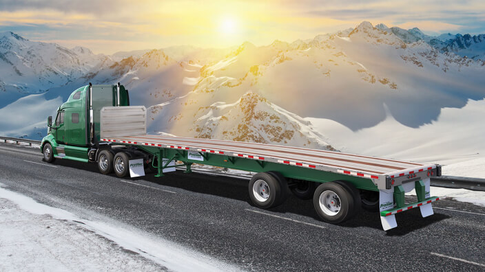 Premier Flatbed truck driving through snowy mountains